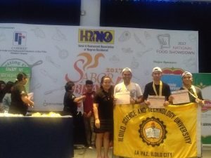 Kenneth Gregg Bargo, Aldrin Cancillar and Christian Pacino proudly holds the ISAT U banner as they receive the certifificate of regognition as the champion of the culinary competition.